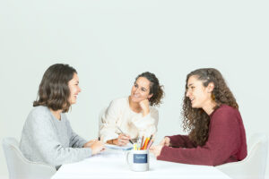 Psicólogas humanistas en Madrid y online charlando en una mesa de trabajo