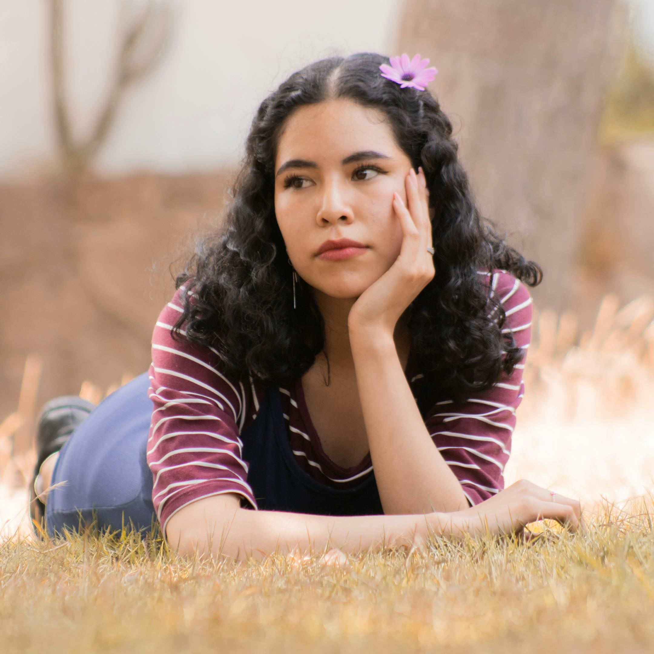 persona tumbada en la hierba con expresión pensativa en un entorno natural tranquilo