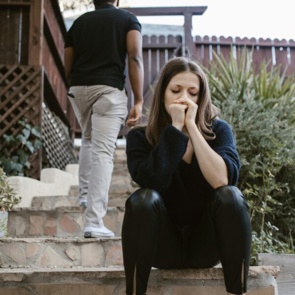 chico de espaldas y chica con rostro preocupado fruto de su dependencia emocional