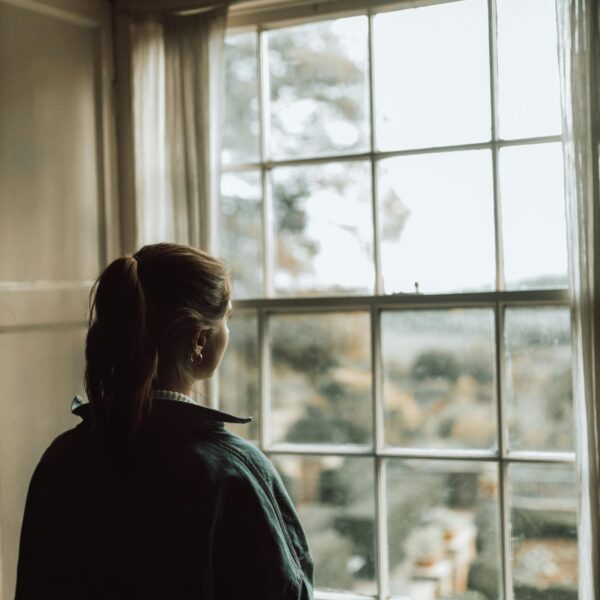 chica reflexiva mirando por la ventana